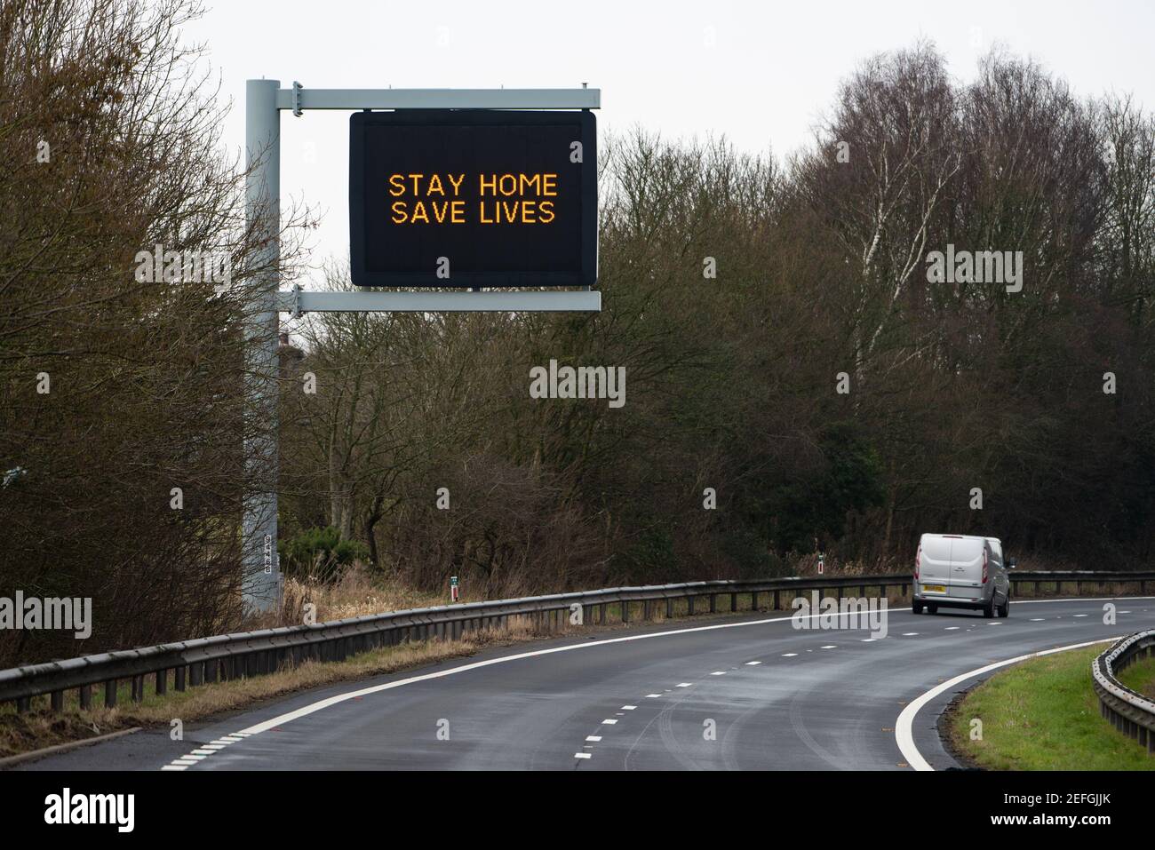 Stay Home Save Lives Zeichen auf der A590 zweispurigen Straße in der Nähe von Kendal, Cumbria, Großbritannien Stockfoto