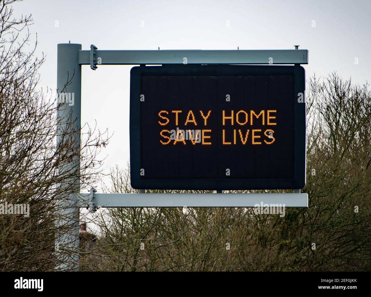 Stay Home Save Lives Zeichen auf der A590 zweispurigen Straße in der Nähe von Kendal, Cumbria, Großbritannien Stockfoto