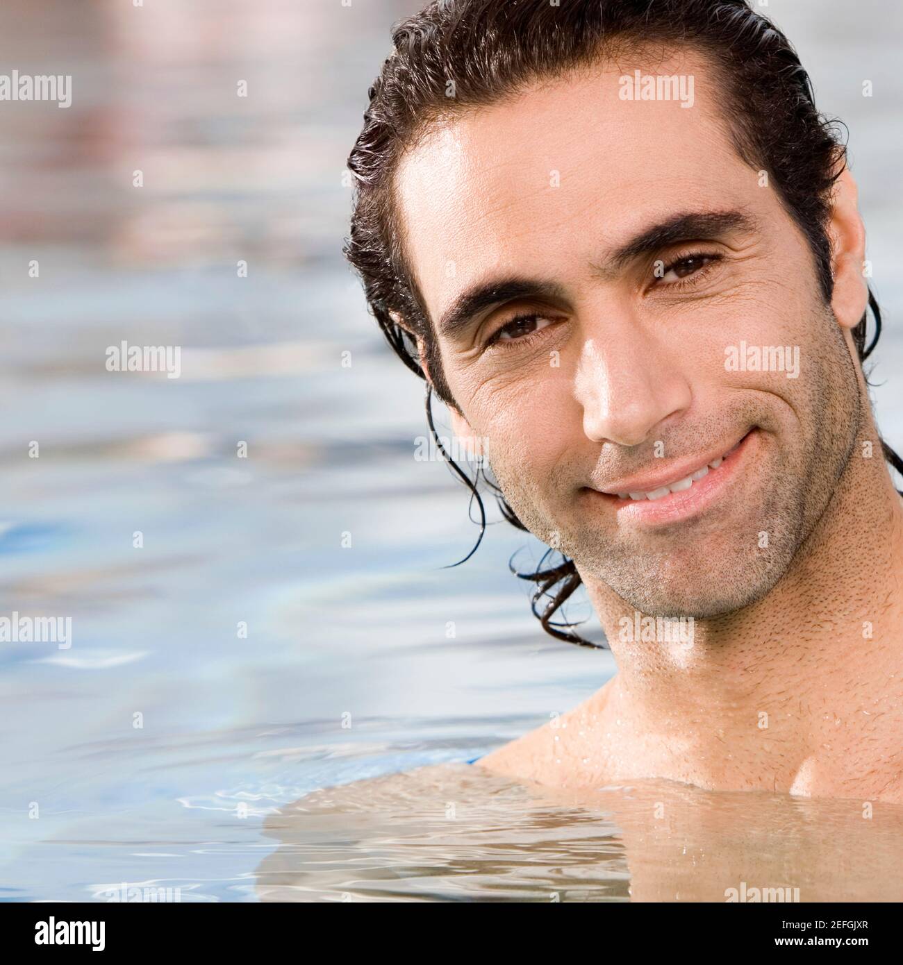 Porträt eines mittleren erwachsenen Mannes, der in einem Schwimmen schwimmt Pool Stockfoto
