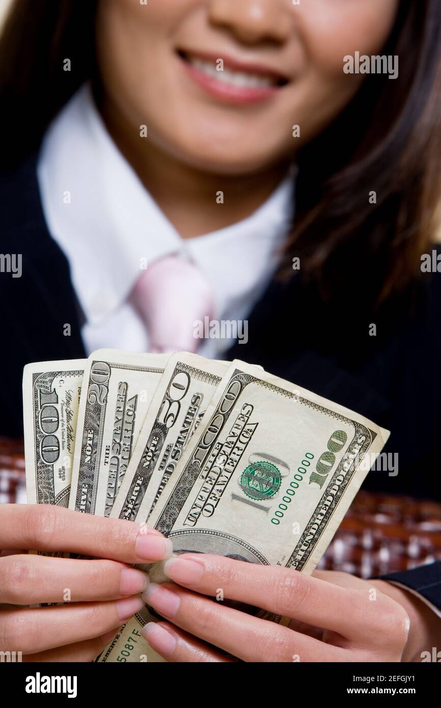 Nahaufnahme einer Geschäftsfrau, die hundert Dollarscheine hält Stockfoto