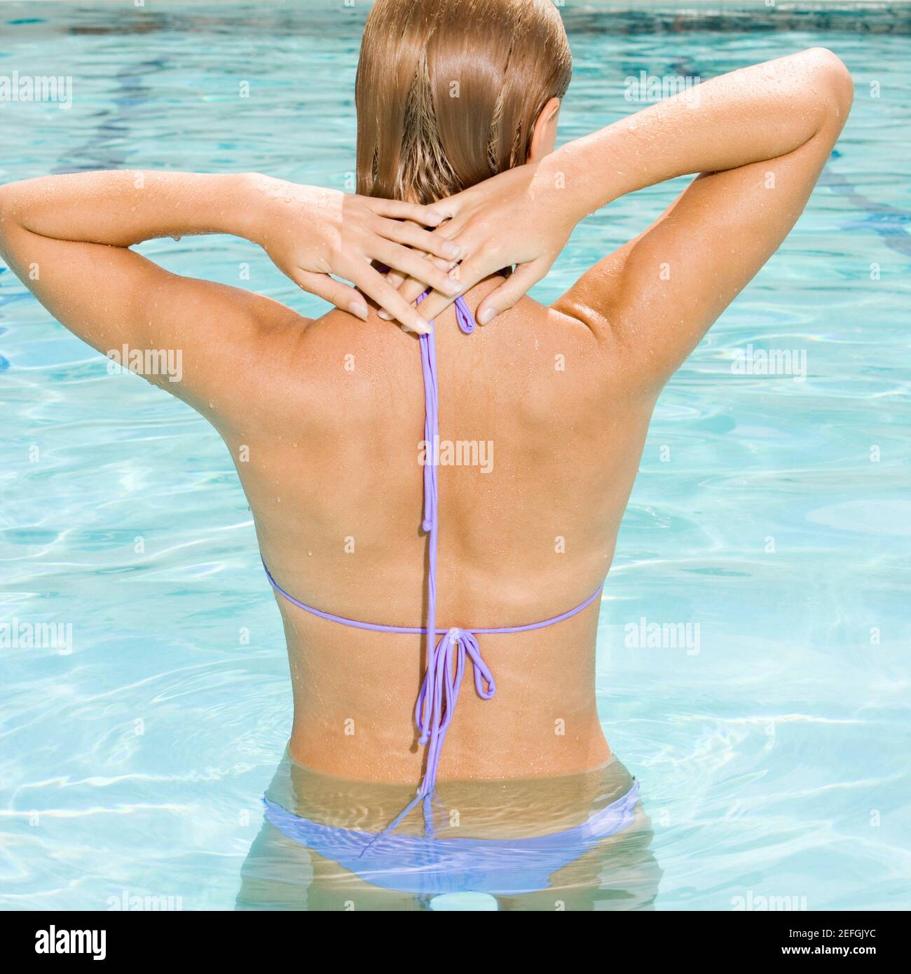 Rückansicht einer jungen Frau in einem Schwimmbad Stockfoto