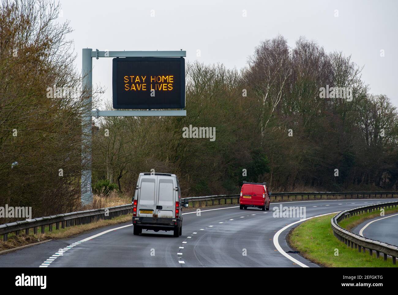 Stay Home Save Lives Zeichen auf der A590 zweispurigen Straße in der Nähe von Kendal, Cumbria, Großbritannien Stockfoto