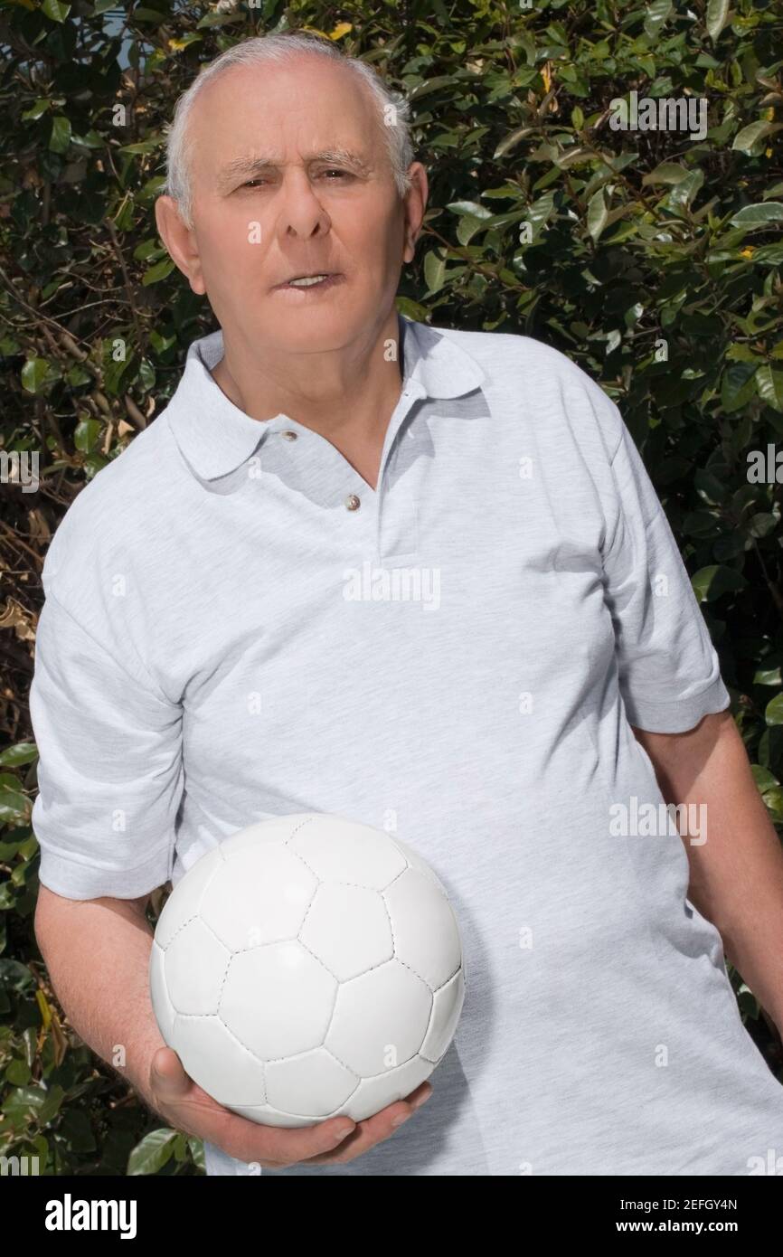 Porträt eines älteren Mannes, der einen Fußball hält Stockfoto
