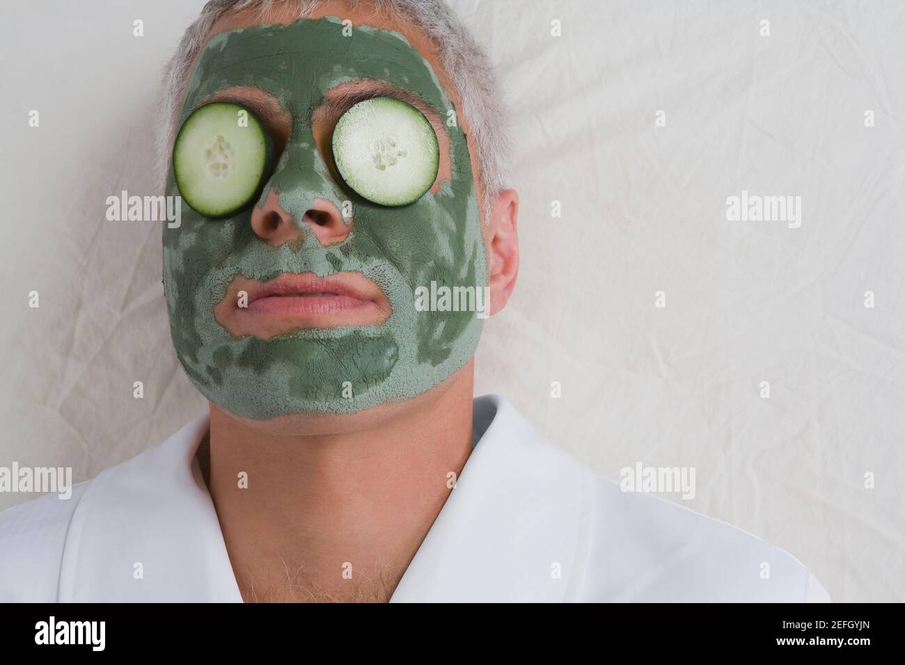 Nahaufnahme eines reifen Mannes, der auf einem Massageliegen liegt Mit Gesichtsmaske auf seinem Gesicht Stockfoto