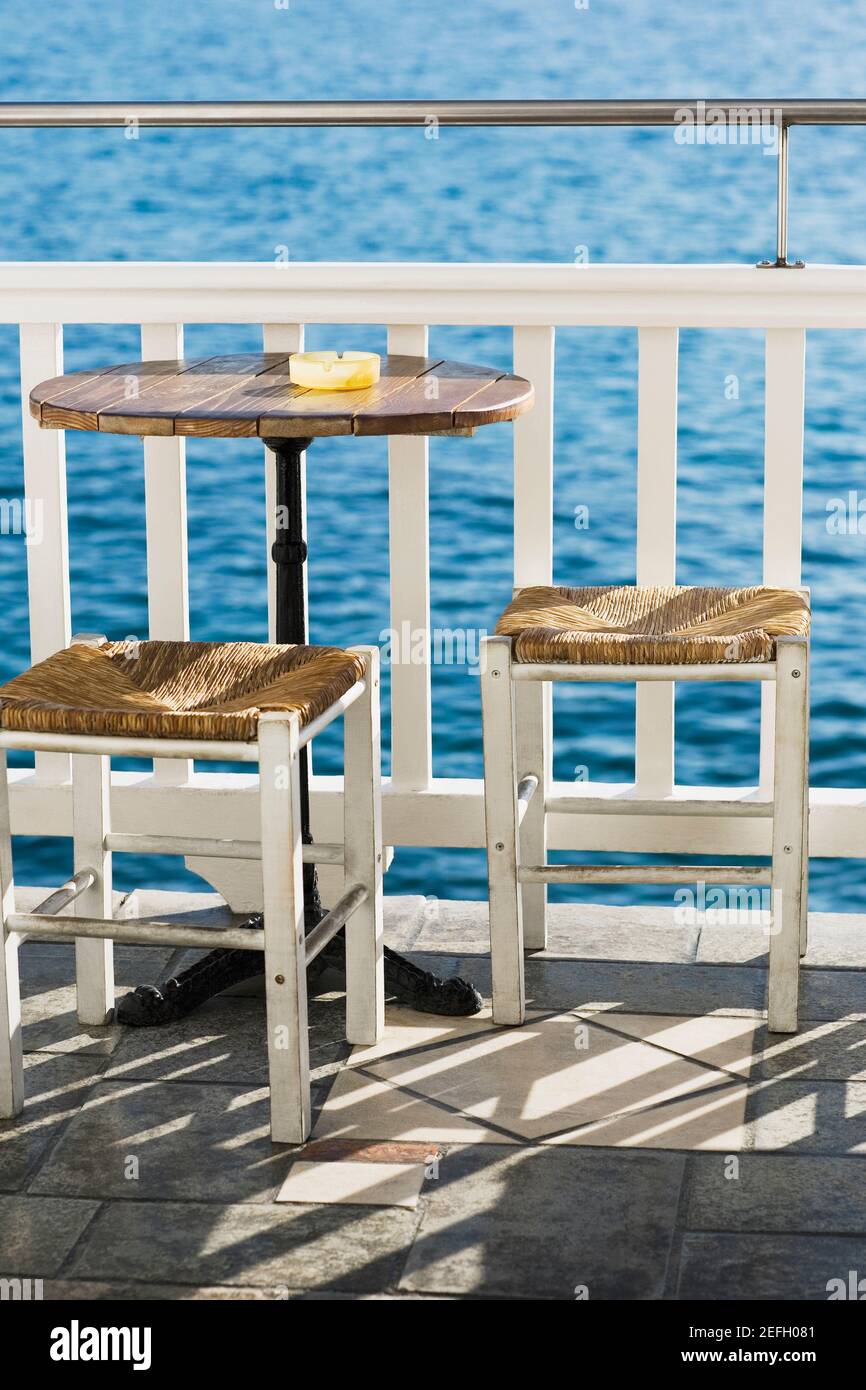 Leerer Tisch mit Hockern in der Nähe eines Geländers in einem Restaurant, Mykonos, Kykladen Inseln, Griechenland Stockfoto