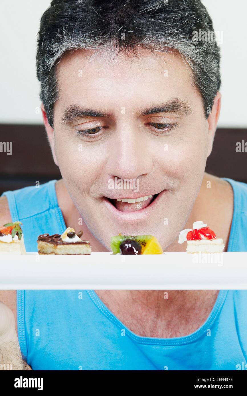 Reifer Mann, der Gebäck ansieht Stockfoto