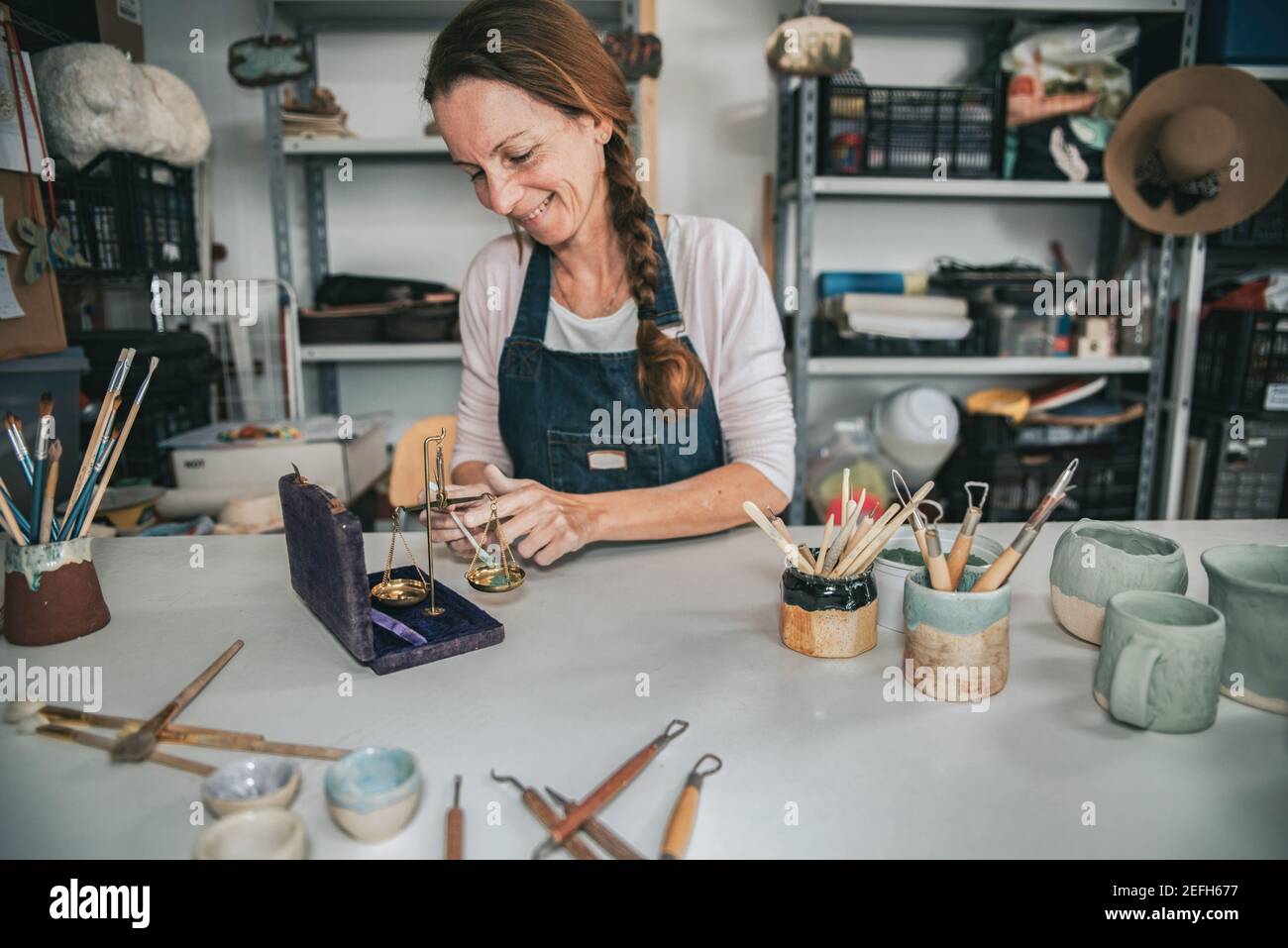 Junge Handwerker Frau arbeitet mit ihren Händen ein Stück Mischfarben aus Keramik Stockfoto