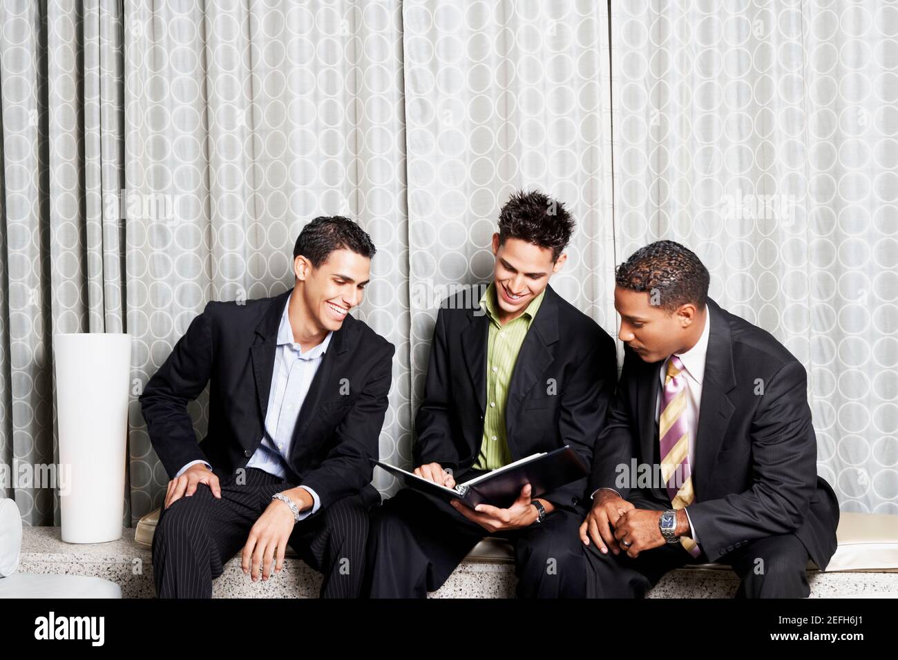 Drei Geschäftsleute, die eine Datei lesen Stockfoto