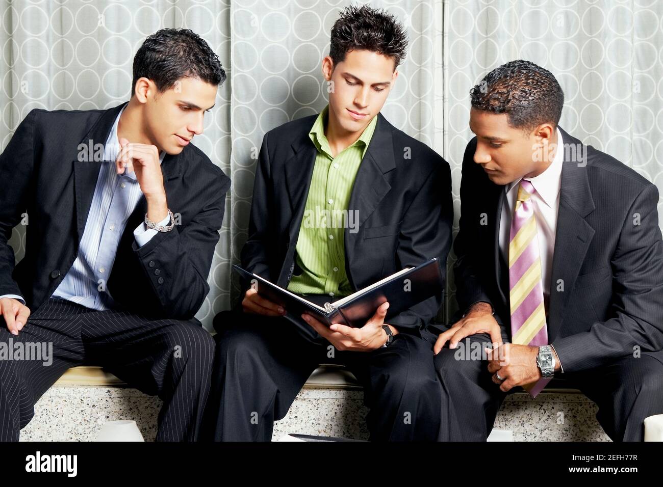 Nahaufnahme von drei Geschäftsleuten, die eine Datei lesen Stockfoto
