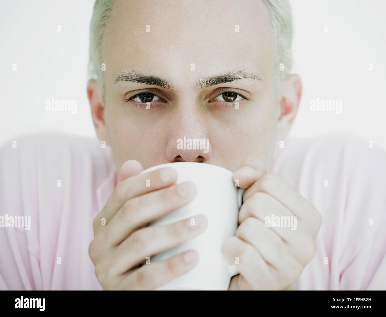 Porträt eines jungen Mannes, der Kaffee aus einer Tasse trinkt Stockfoto