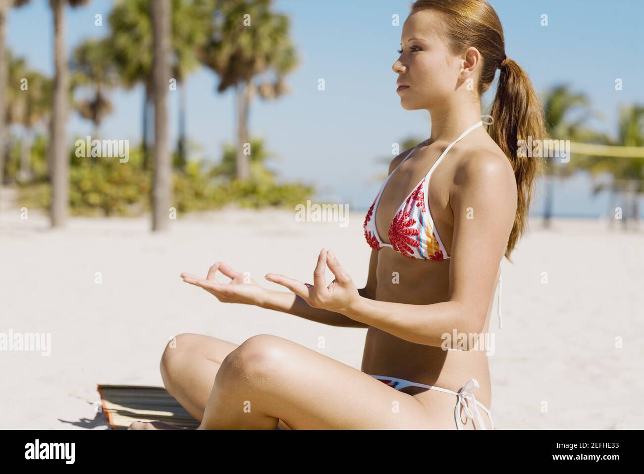 Seitenansicht einer jungen Frau, meditieren am Strand Stockfoto