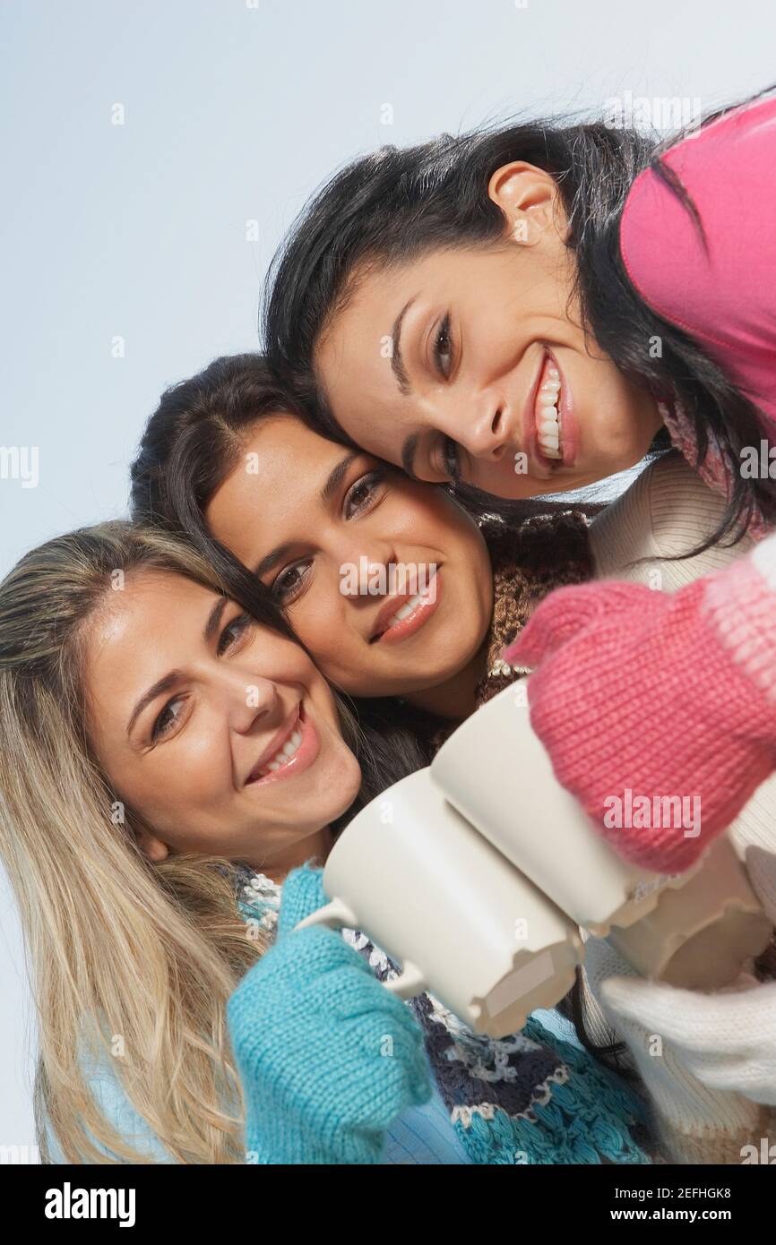 Porträt von zwei jungen Frauen und einer mittleren erwachsenen Frau Toasting Kaffeebecher Stockfoto