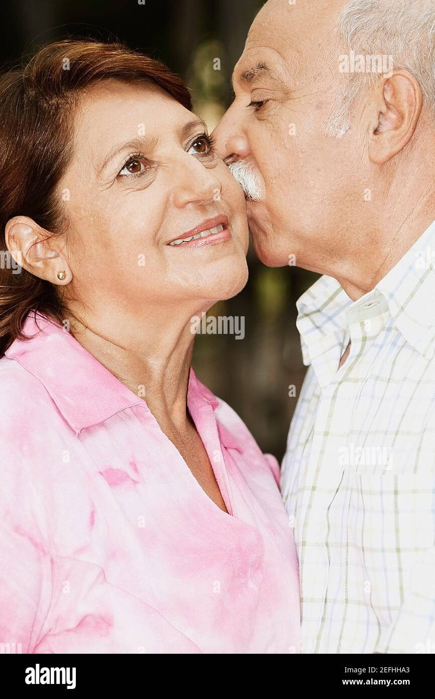 Reifer Mann küsst eine reife Frau Stockfoto
