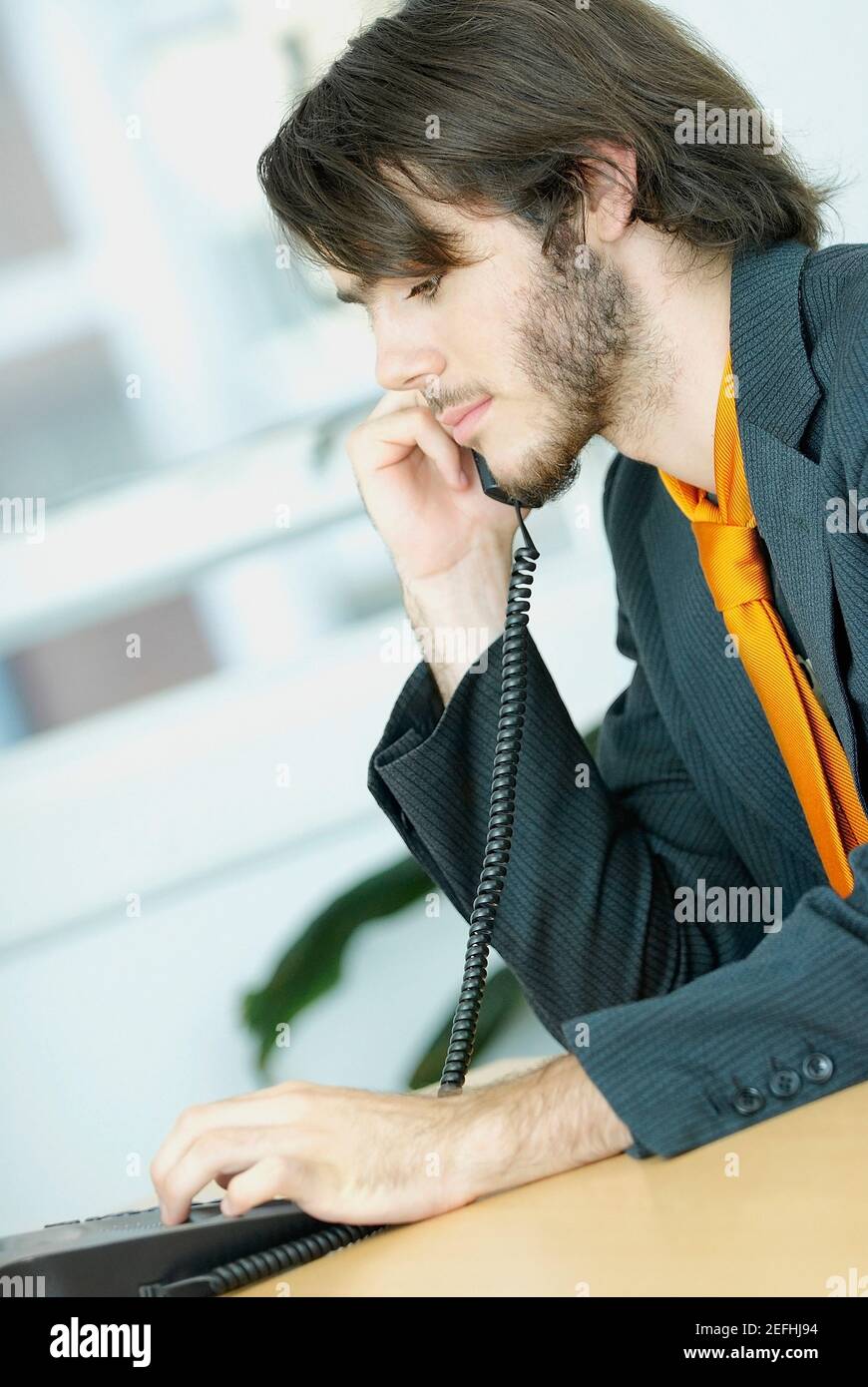 Nebenprofil eines Geschäftsmannes, der ein Telefon benutzt Stockfoto
