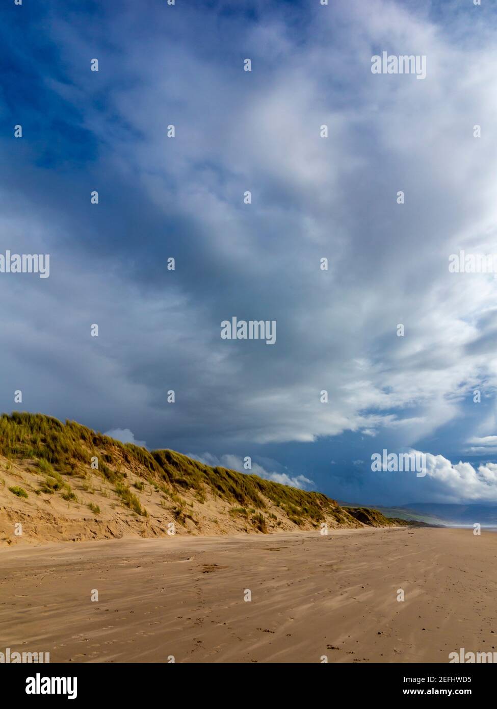 Der Sandstrand bei Morfa Dyffryn zwischen Barmouth und Harlech in Gwynedd an der Nordwestküste von Wales mit stürmischem Himmel darüber. Stockfoto