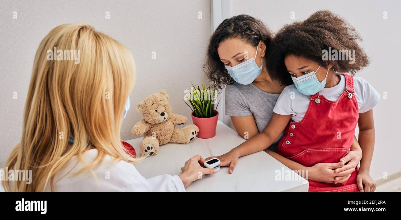 Der Arzt misst Sauerstoffsättigung und Puls eines Kindes in der Arztpraxis Stockfoto