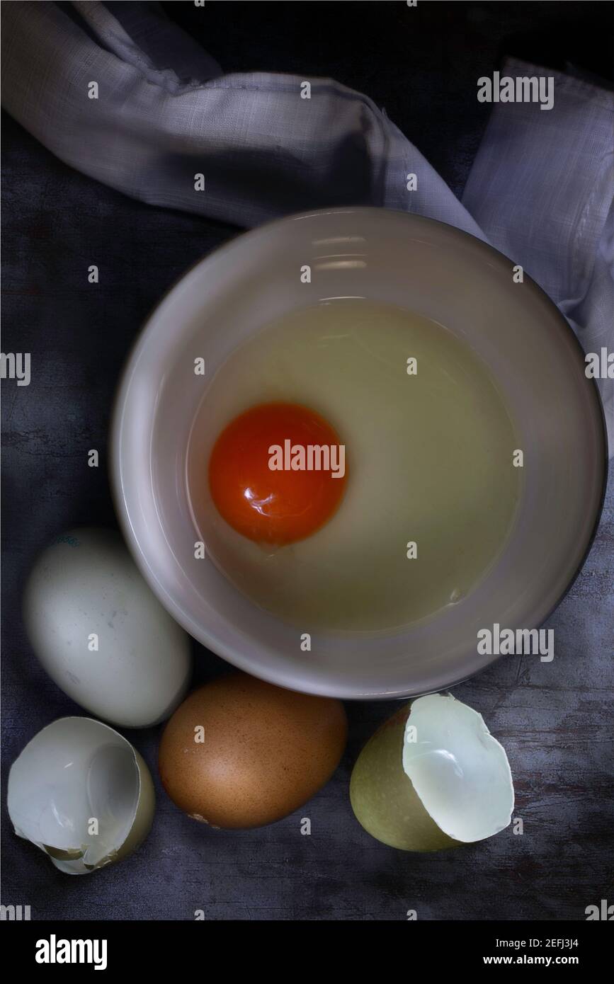 Flache Lage von rohen Eiern und Eigelb in der Schüssel Stockfoto