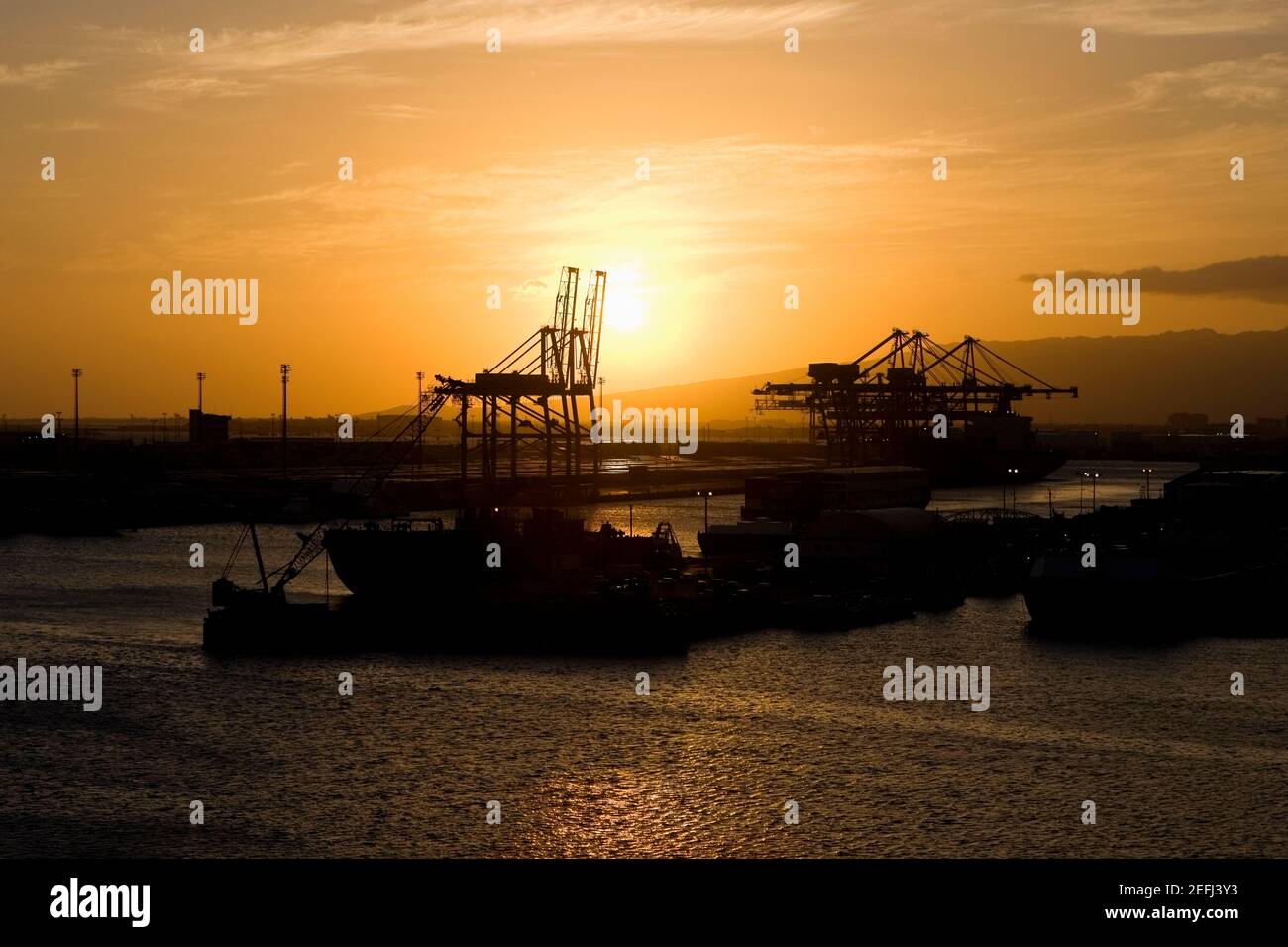 Silhouette eines Containerschiffes und Kräne auf einem kommerziellen Andocken Stockfoto