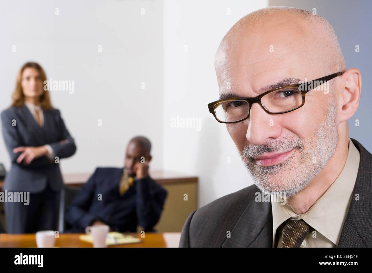 Porträt eines Geschäftsmannes mit seinen Kollegen im Hintergrund Stockfoto