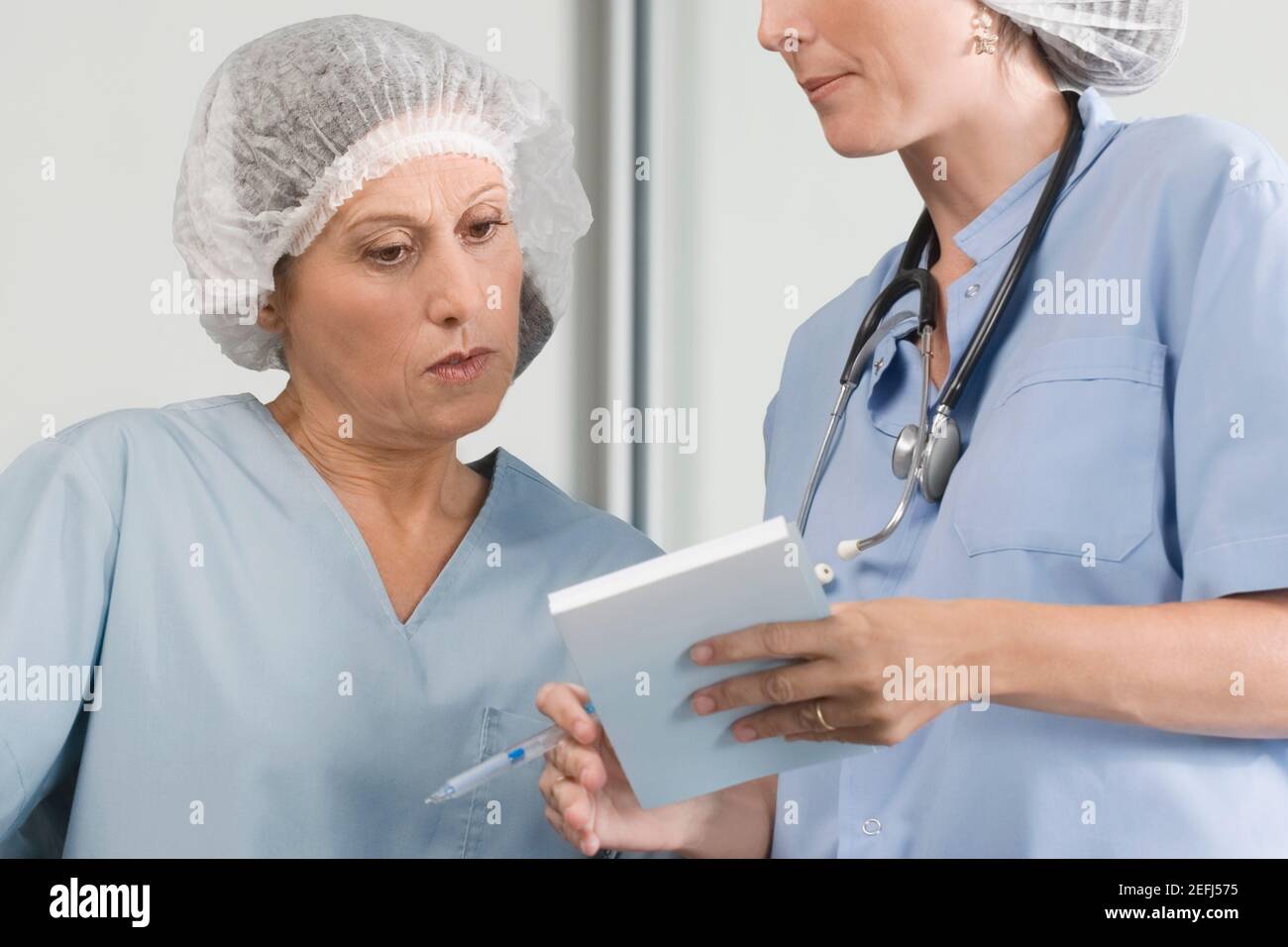 Zwei männliche Chirurgen diskutieren einen medizinischen Bericht Stockfoto