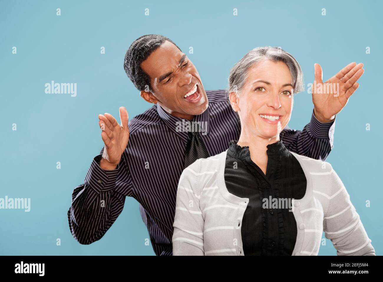 Porträt einer Geschäftsfrau lächelnd mit einem Geschäftsmann schreien an Sie Stockfoto