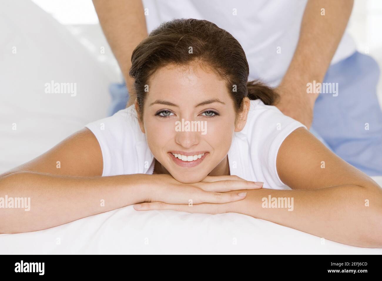 Porträt einer jungen Frau, die eine Rückenmassage bekommt Ein junger Mann Stockfoto