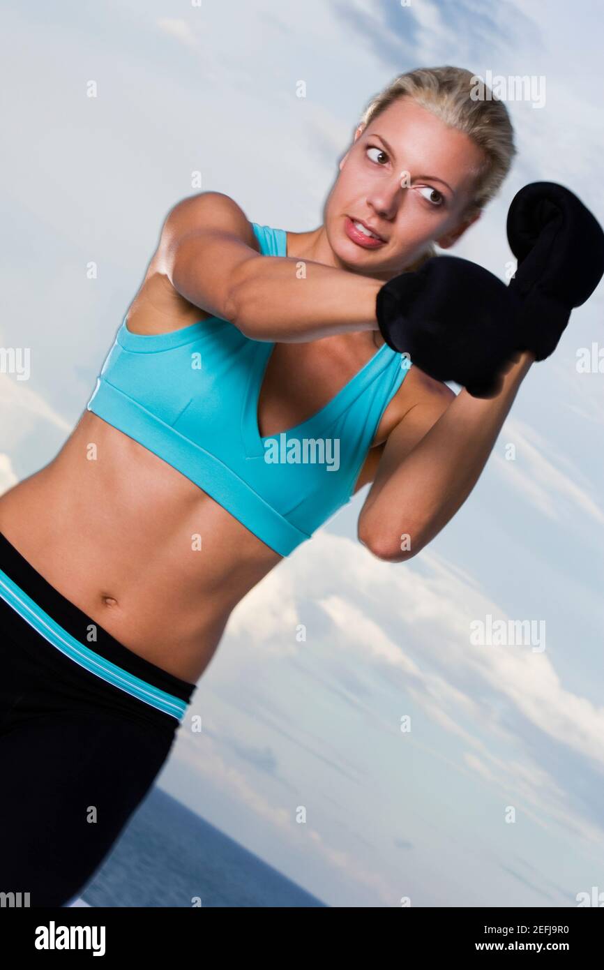 Low-Angle-Ansicht einer jungen Frau mit Boxhandschuhen Stockfoto