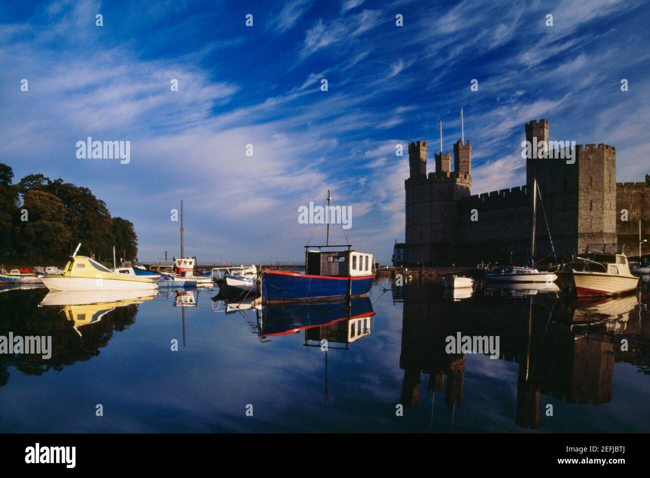 Seitenansicht des Caernarvon Castle von einem Fluss in Wales Stockfoto