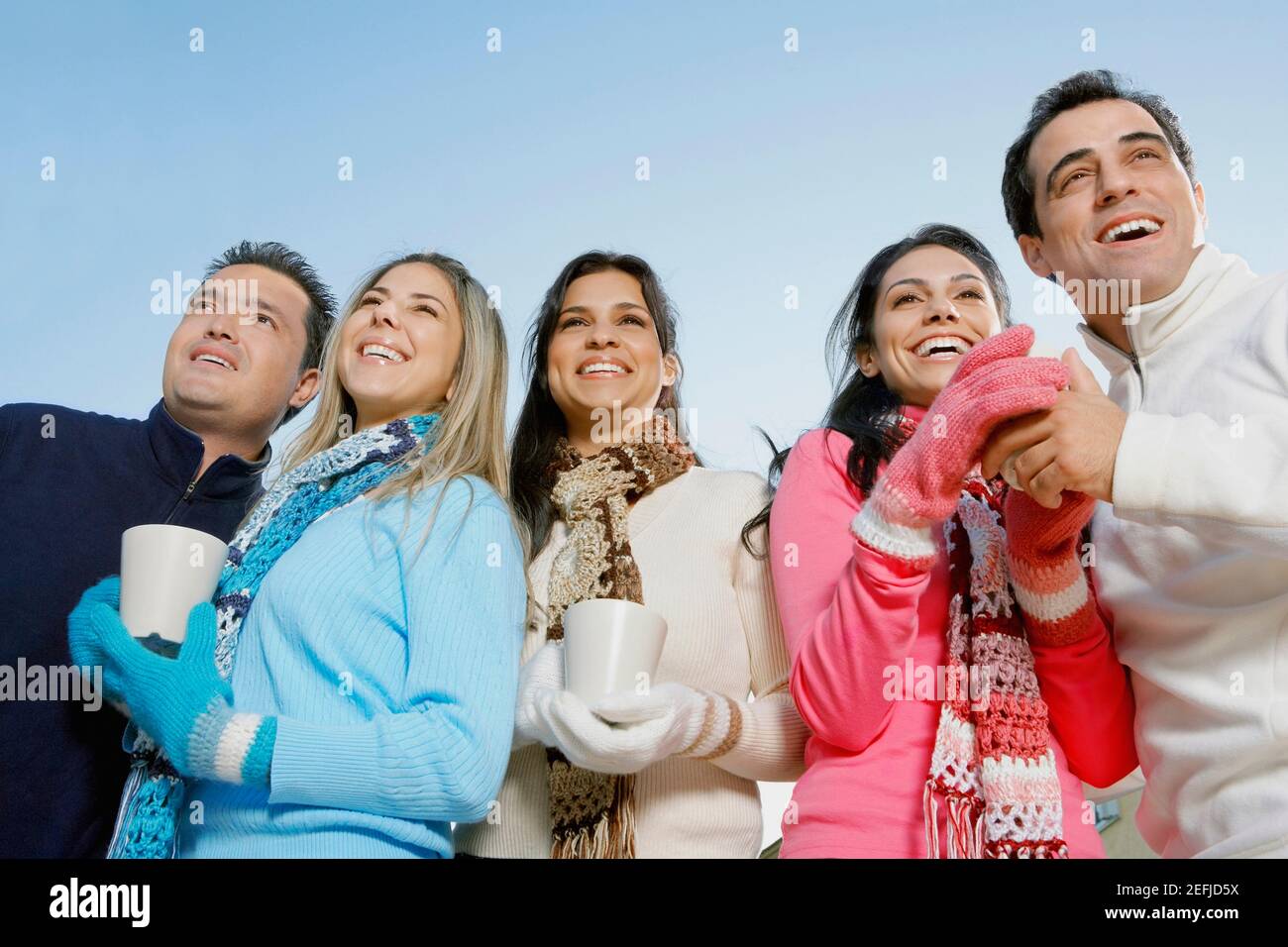 Low-Angle-Ansicht von zwei jungen Frauen und zwei Mitte Erwachsene Männer mit einer mittleren erwachsenen Frau lächeln und halten Teetassen Stockfoto