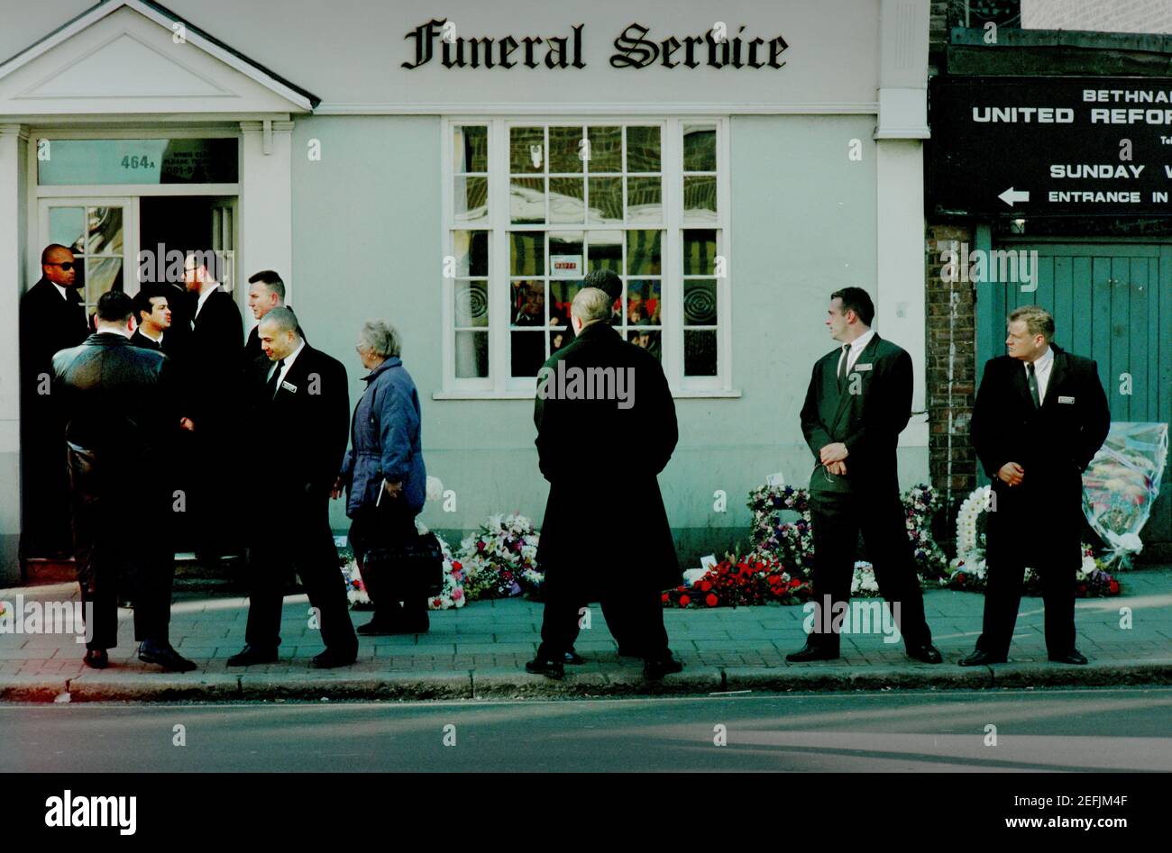 Ronnie Kray Beerdigung Bethnal Green East London England 29. März 1995 Scans von 2021 Sicherheitsbetretern warten auf W. English Funeral Offices auf Bethnal Gree Road Funeral of East End of London Gangster Ronnie Kray, Zwilling des verbrechenden Chefs Reggie Kray, der an der Beerdigung teilnahm, als es sich seinen Weg durch Ost-London zum Familiengrundstück auf dem Friedhof von Chingford im Nordosten Londons verwickelte. Stockfoto