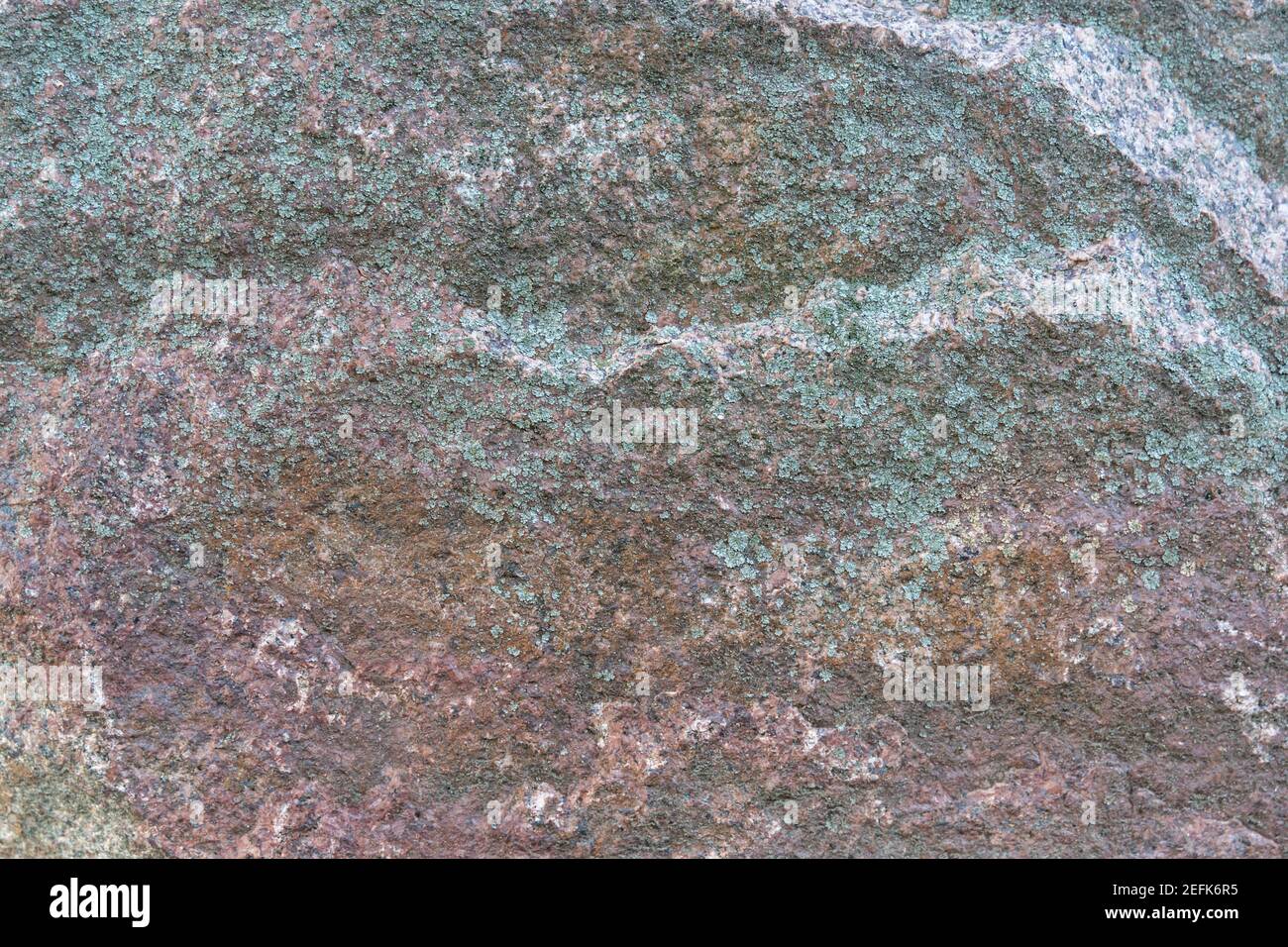 Texturmuster eines roten Granitsteinfelsen mit verwitterten Gealterte Grunge-Struktur Stockfoto