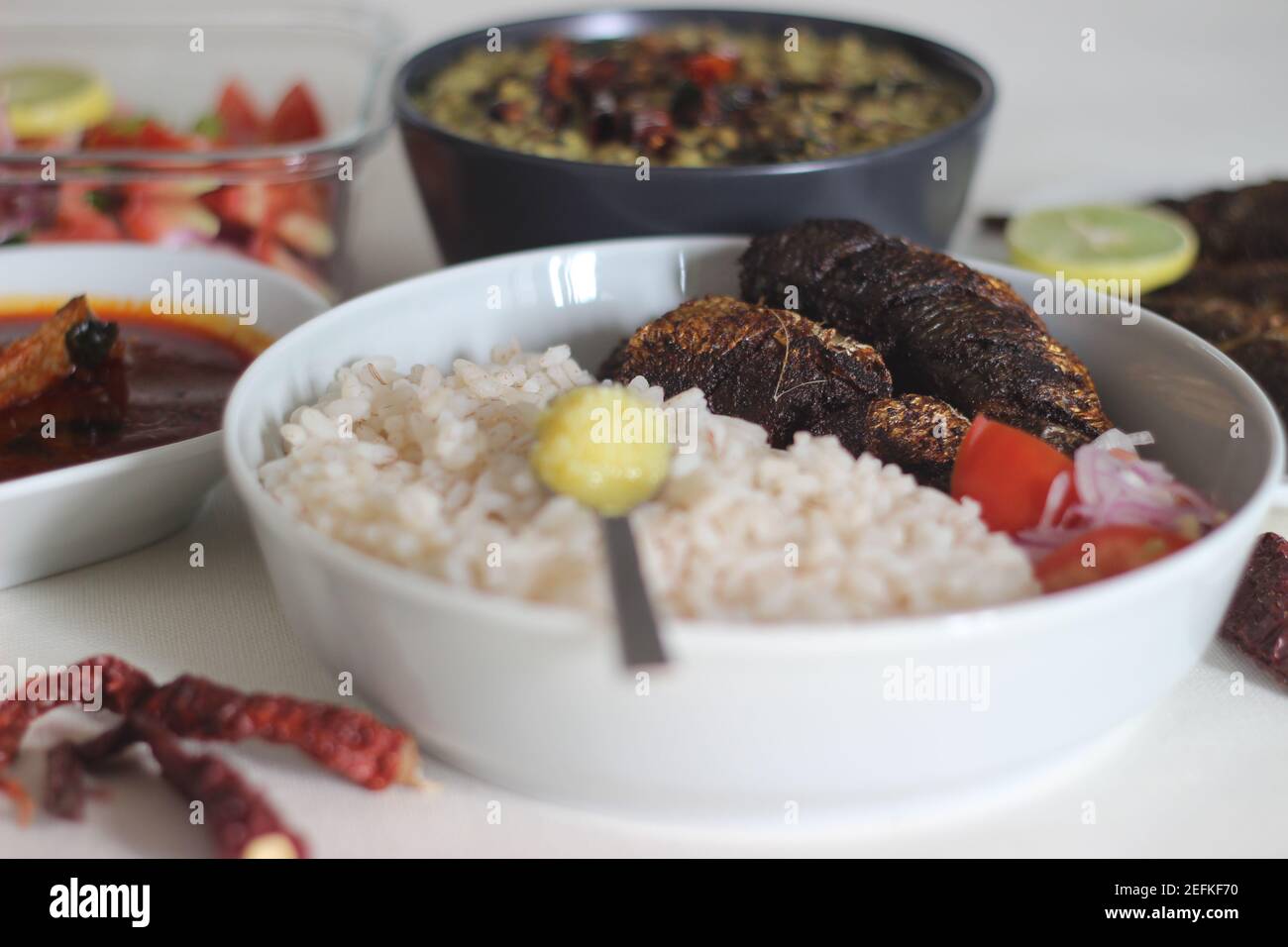 Kerala Mahlzeiten mit rotem Reis, Sardinen Curry, Sardinen braten und Kokosnuss-basierte grüne Gramm Curry. Alles im traditionellen kerala-Stil zubereitet Stockfoto