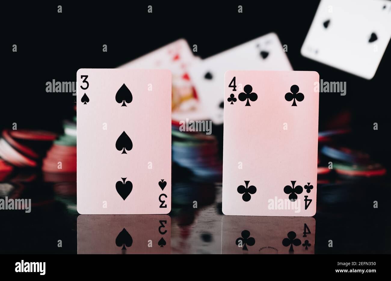 Poker-Karten mit Chips auf schwarzem Hintergrund Stockfoto