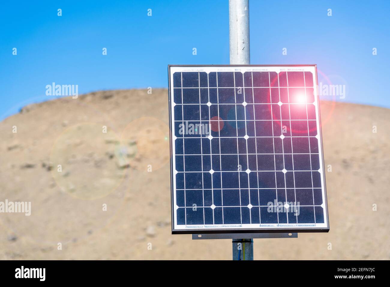 Kleines Solarpanel entlang einer Straße in einer abgelegenen Wüstenlage und blauem Himmel. Streulicht. Stockfoto