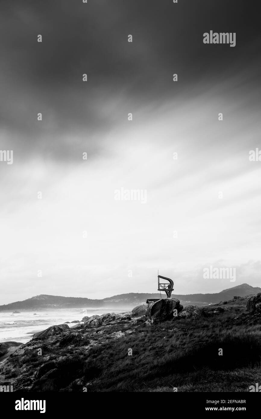 Steinige Küste unter einem dunklen Himmel, im Meer von Galicien Stockfoto