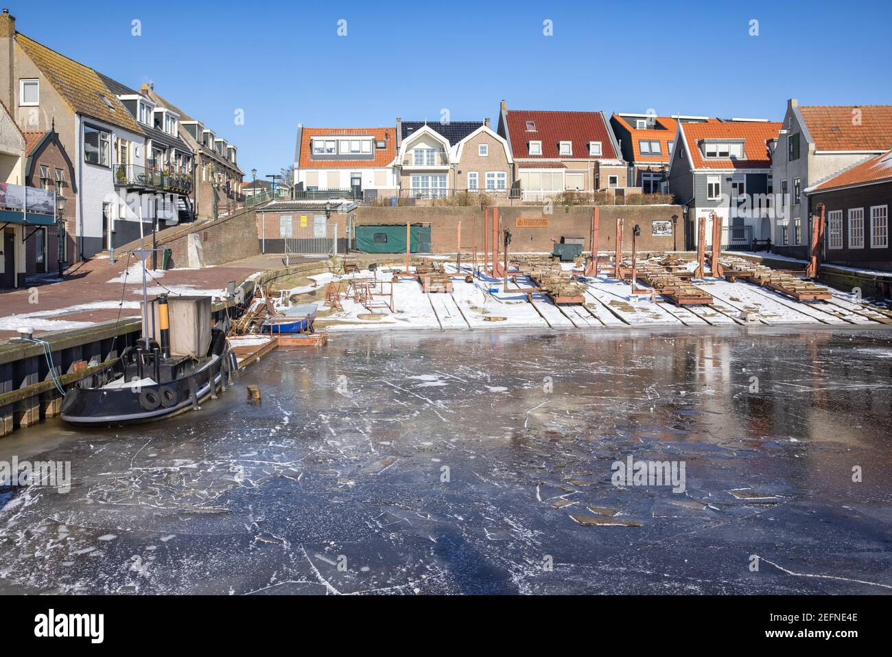 Gefrorener Hafen von urk mit Werft und altem Schlepper Stockfoto