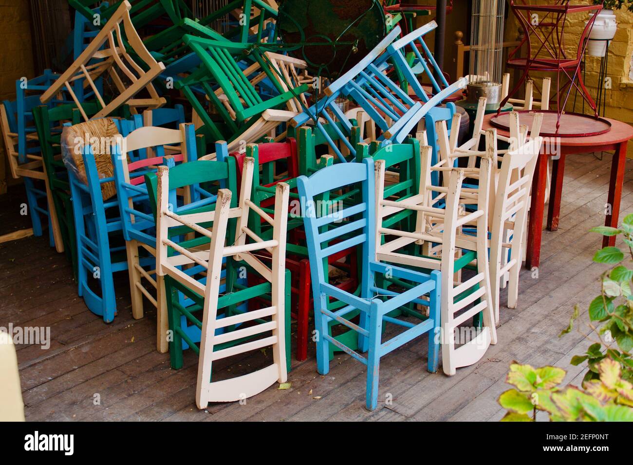 Bunte Stühle stapelten sich aus einem geschlossenen Restaurant wegen COVID19 in Plaka, Athen. Stockfoto
