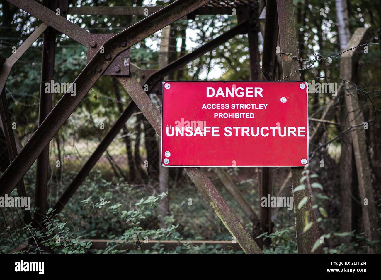 Gefahr Schild mit unsicherer Struktur am rostigen alten Metallturm angebracht Das ist in einem heruntergekommenen Zustand verkommen Verletzungsgefahr Stockfoto