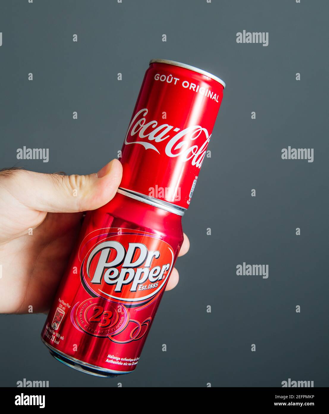 Paris, Frankreich - 3. Mai 2020: POV männliche Hand mit Aluminiumdose von Coca Cola und Dr. Pepper hergestellt von Dr. Pepper Snapple Group Softdrinks - isoliert vor grauem Hintergrund Stockfoto