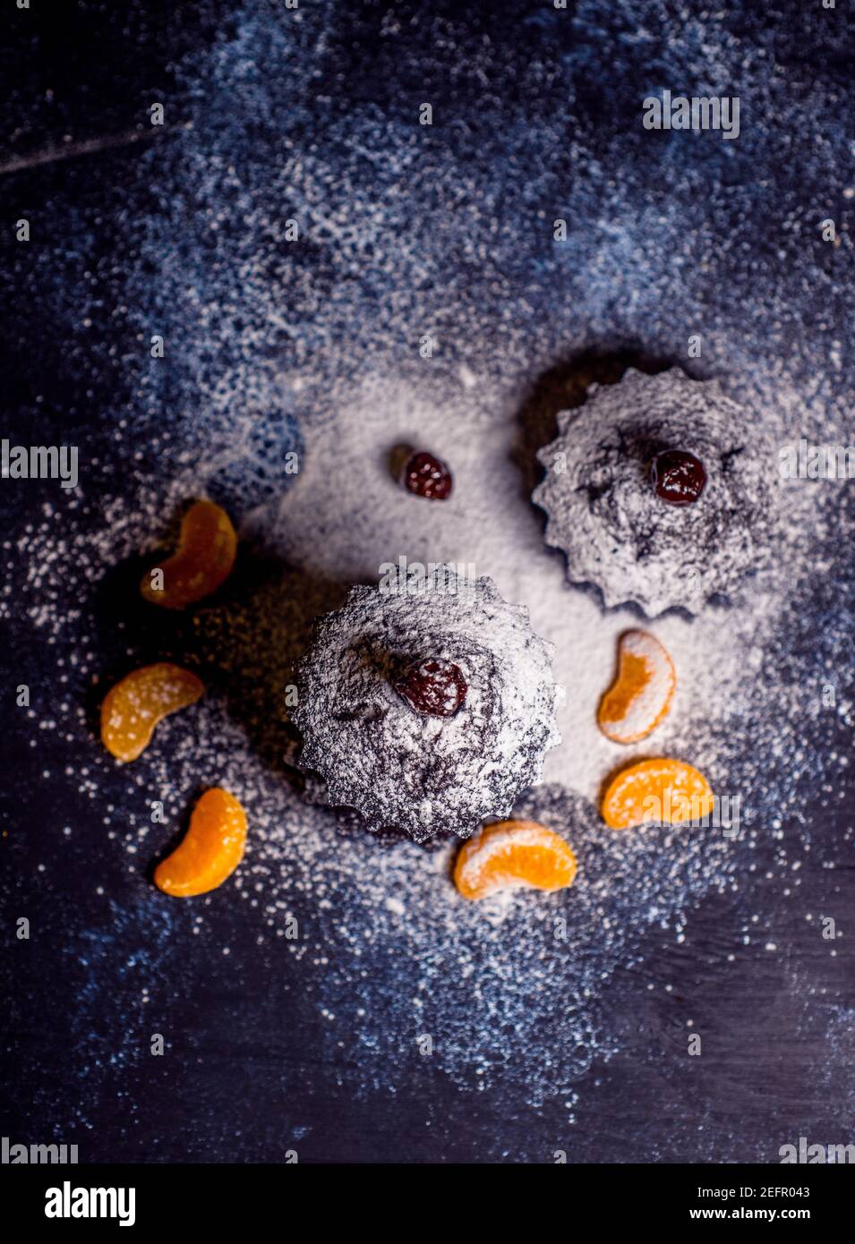 Schokoladen-Muffins bestreut mit Leckereien mit Kirschen und Schokolade und Kakao Stockfoto