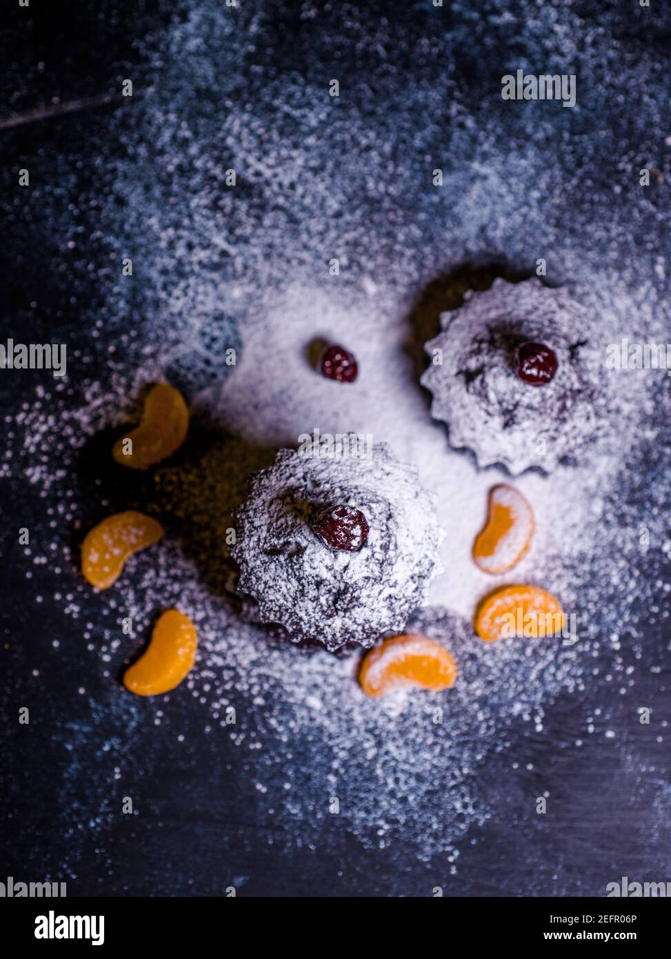 Schokoladen-Muffins bestreut mit Leckereien mit Kirschen und Schokolade und Kakao Stockfoto