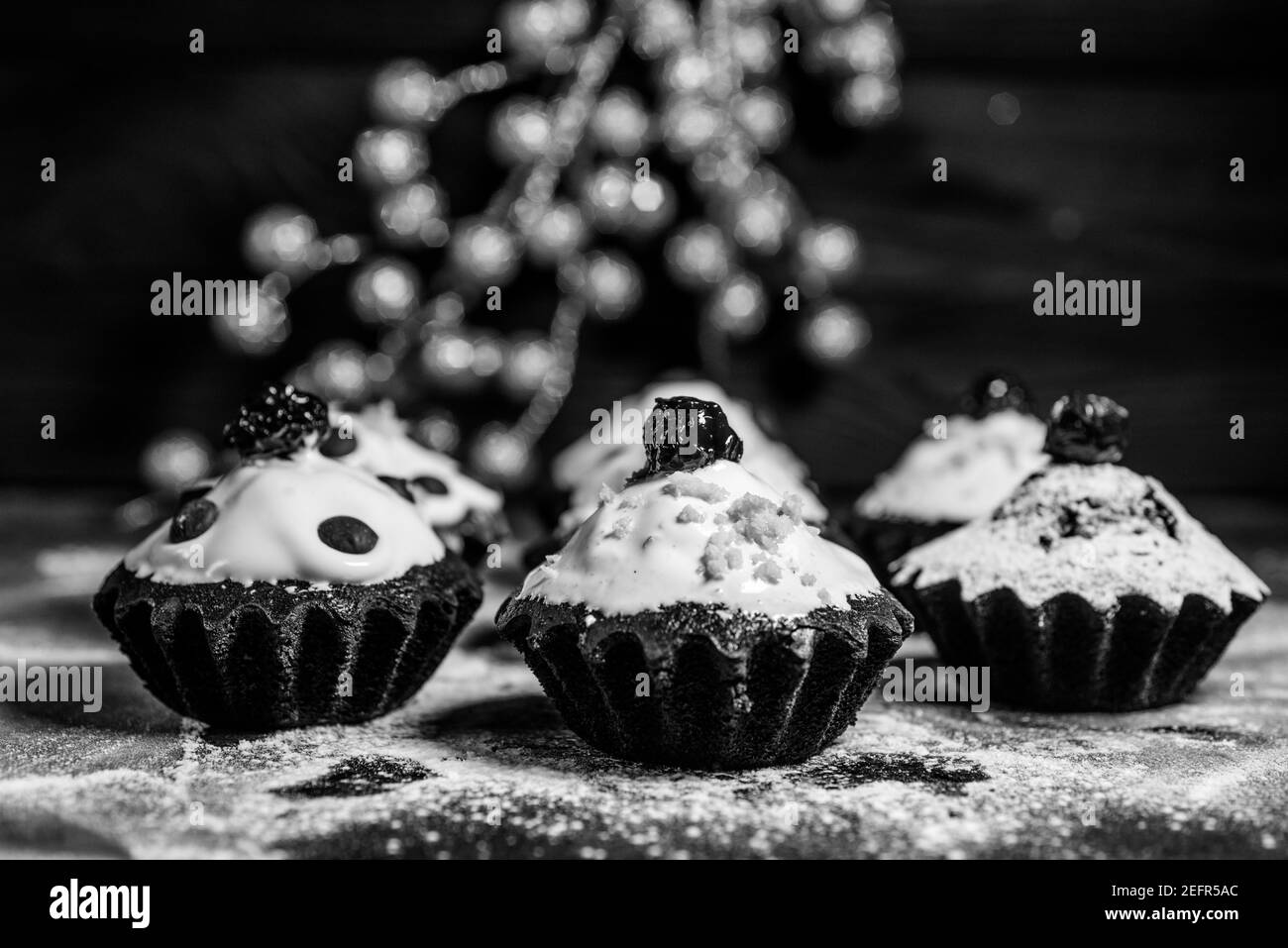 Schokoladen-Muffins bestreut mit Leckereien mit Kirschen und Schokolade und Kakao Stockfoto