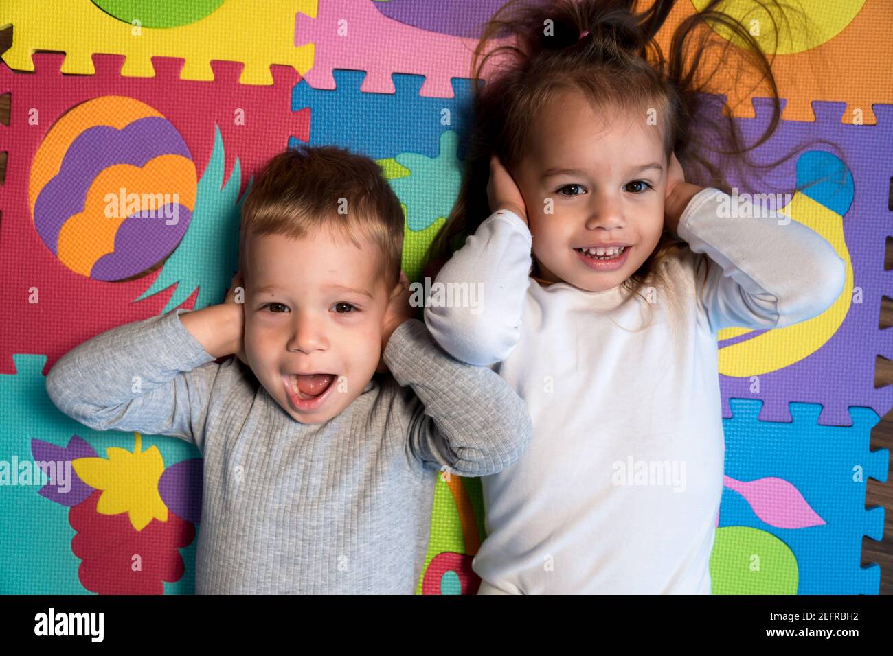 Kindheit, Familie Freundschaft, Spiele - close up Portrait zwei lustige Freude glücklich lächelnd kleines Kleinkind peschool Kinder Geschwister Zwillinge Bruder mit Schwester Stockfoto