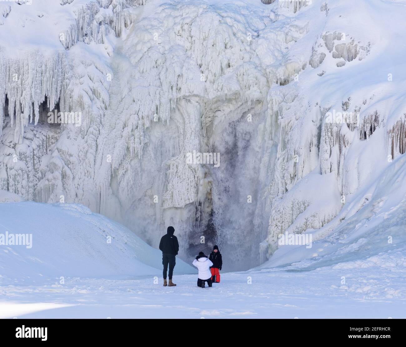 Eine Mutter, die ein Foto von ihrem Kind in den gefrorenen Rutschen de la Chaudière in Charny Hear Quebec City, Kanada, macht Stockfoto