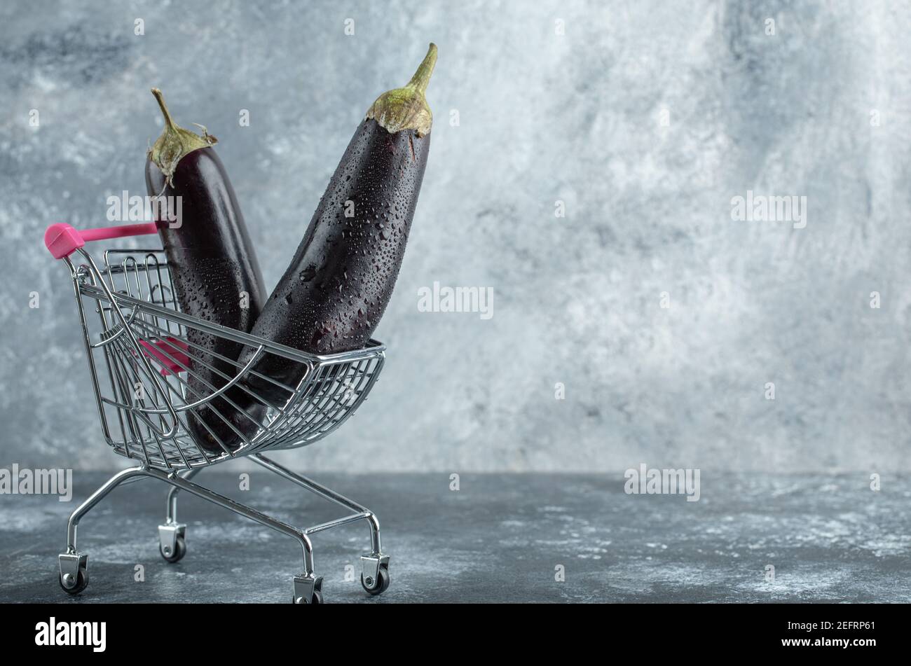 Reife lila Auberginen im kleinen Warenkorb Stockfoto