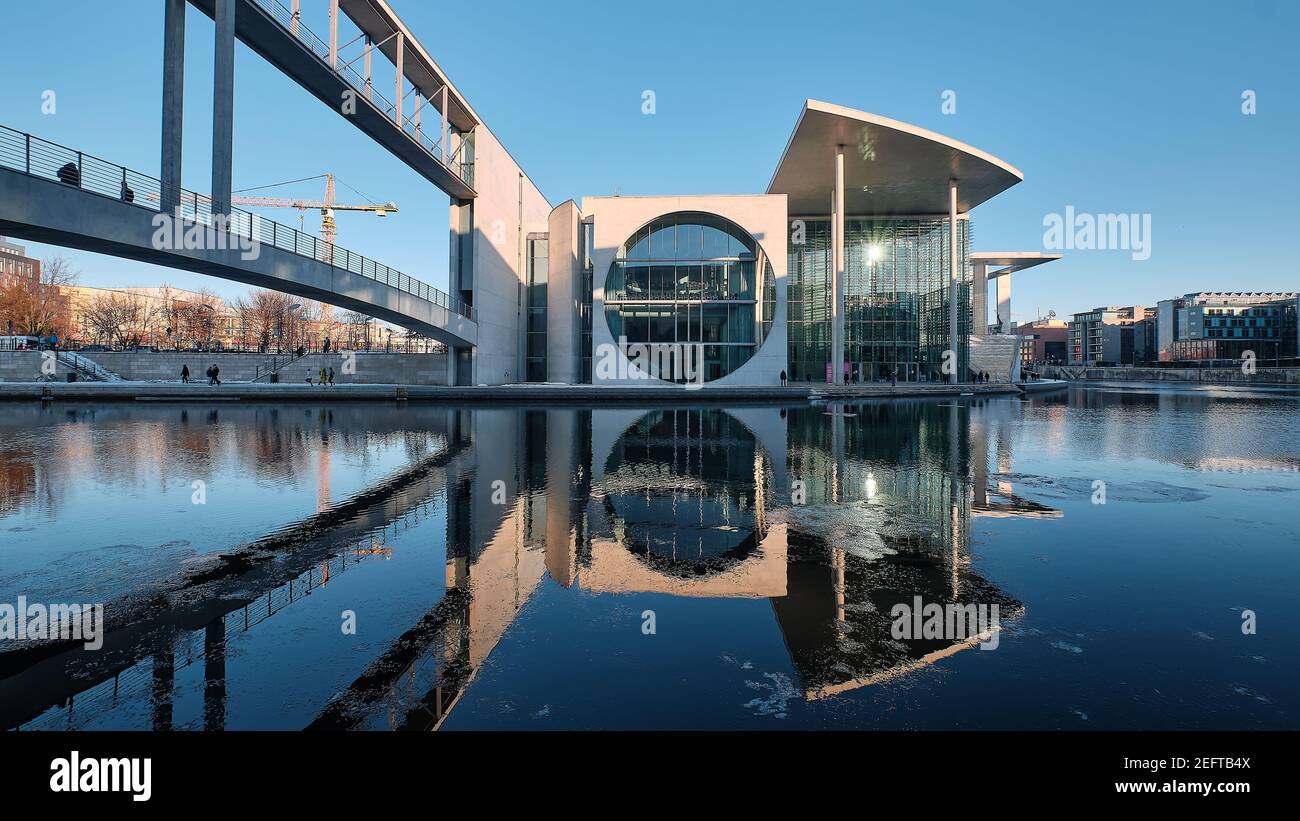 Pier Paul-Loebe-Haus Reichstag. Panorama-Winterblick von der Fußgängerbrücke über die Spree. Ruhiger Abend, Wasser mit Reflexionen, Eis auf Wasser Stockfoto