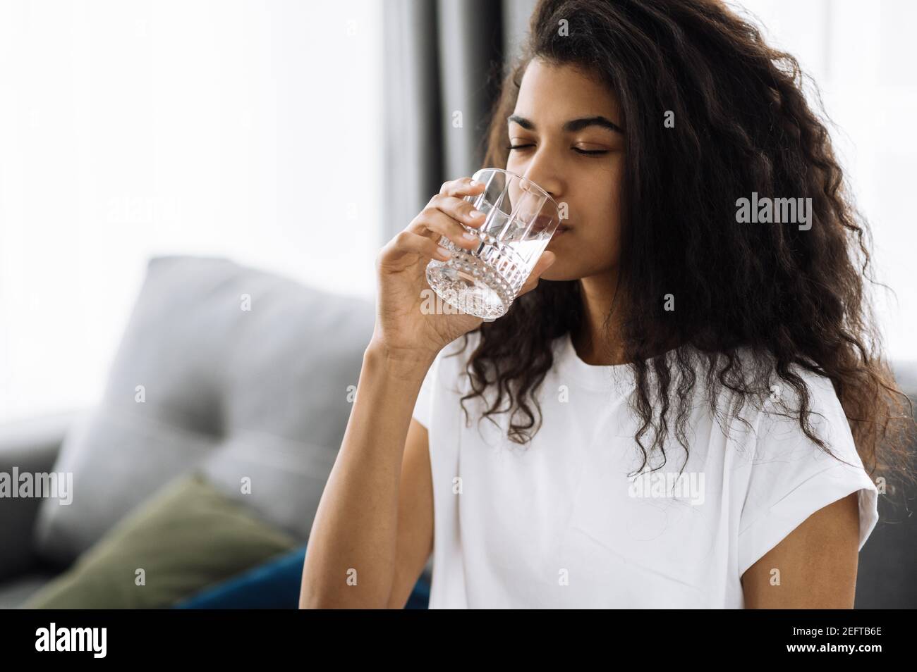 Schöne Mädchen folgen gesunden Lebensstil, trinken ein reines Wasser. afroamerikanische Frau trinken täglich Menge an sauberem Wasser, gesunde Lebensweise Konzept Stockfoto