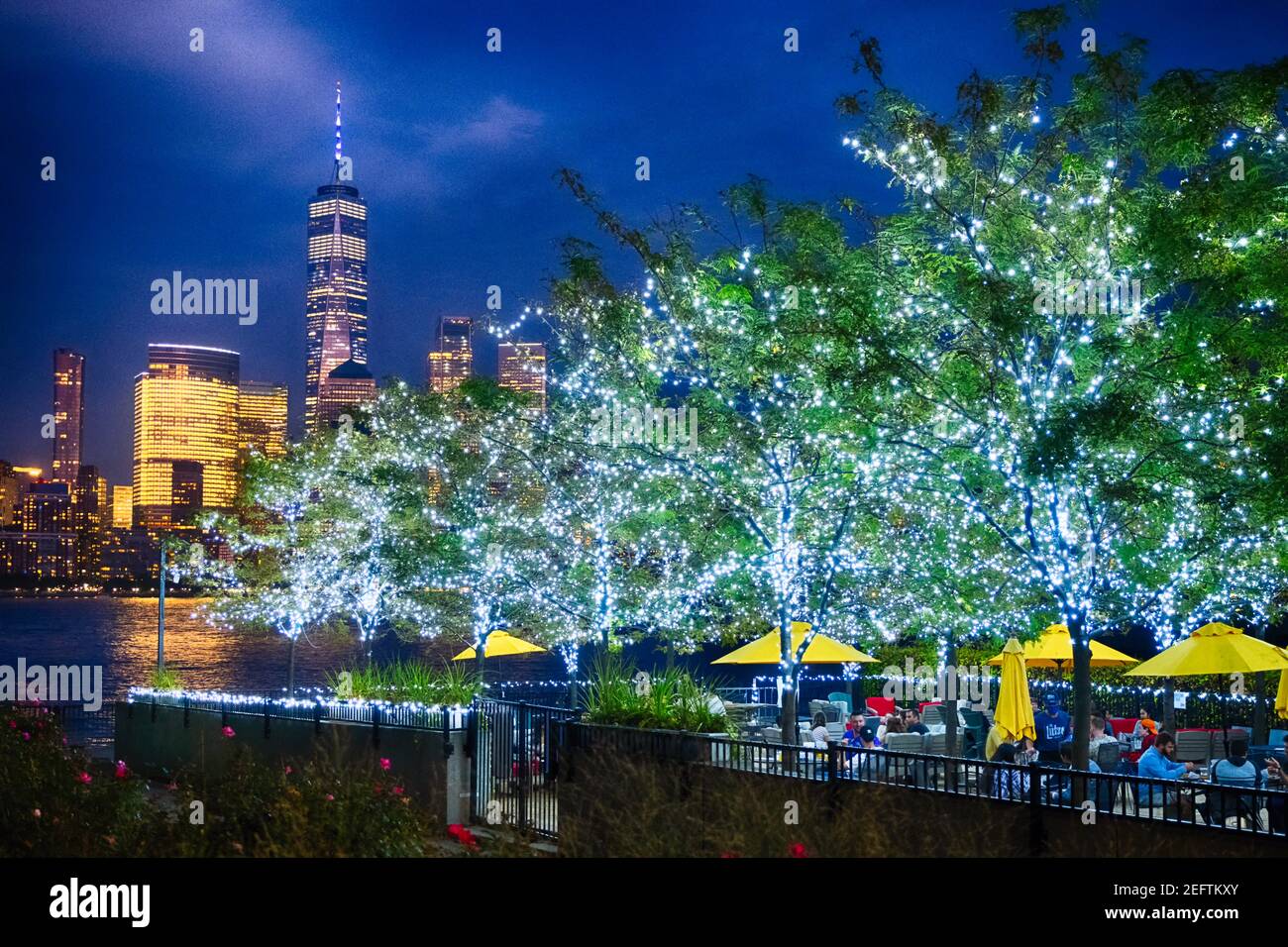 Restaurant Patio mit beleuchteten Bäumen mit Blick auf Lower Manhattan, Newport, Jersey City Stockfoto