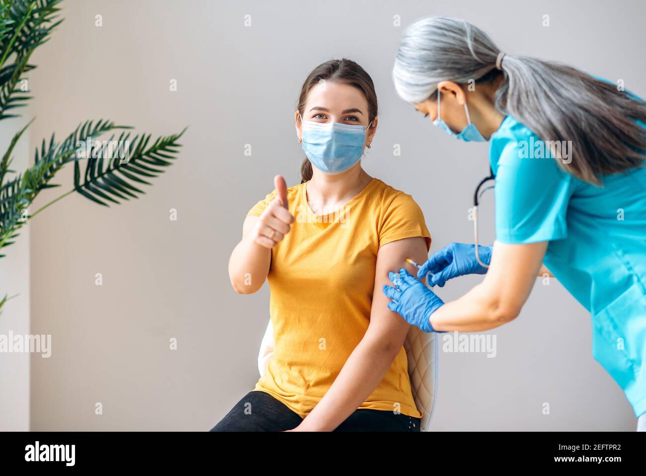 Coronavirus-Präventionskonzept. Frau trägt medizinische Maske bekommen Coronavirus Covid19 Impfstoff im Krankenhaus. Weibliche Krankenschwester oder Ärztin mittleren Alters, die dem Patienten einen Impfstoff verabreichen Stockfoto