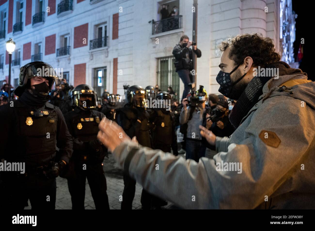 Madrid, Spanien. Februar 2021, 17th. Ein Protestler, der bei einer Demonstration gegen die Inhaftierung des spanischen Rappers Pablo Hasel wegen einiger Liedtexte und Tweets, die die spanische Monarchie kritisieren, der Polizei gegenübersteht. Quelle: Marcos del Mazo/Alamy Live News Stockfoto